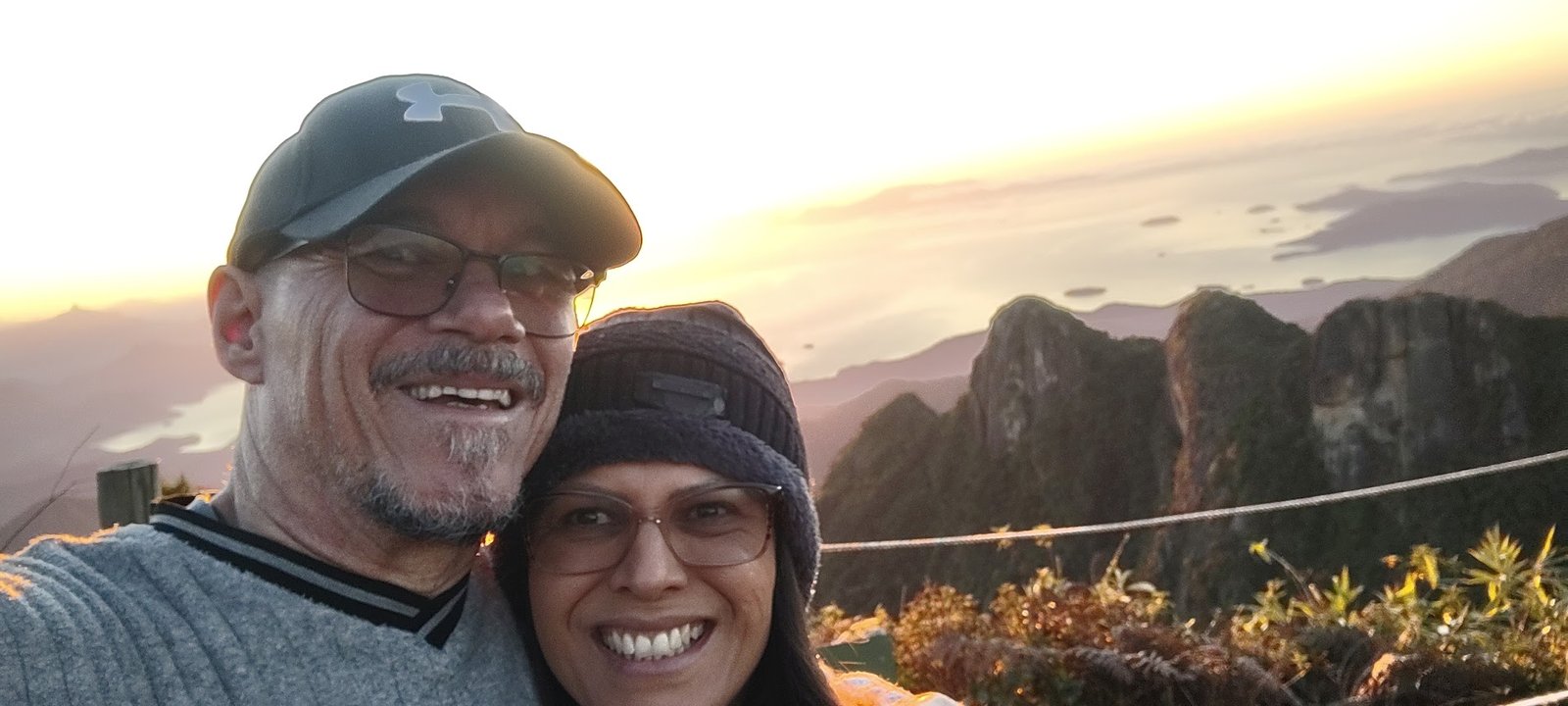 Casal registra a chegada do dia no topo da Pedra da Macela