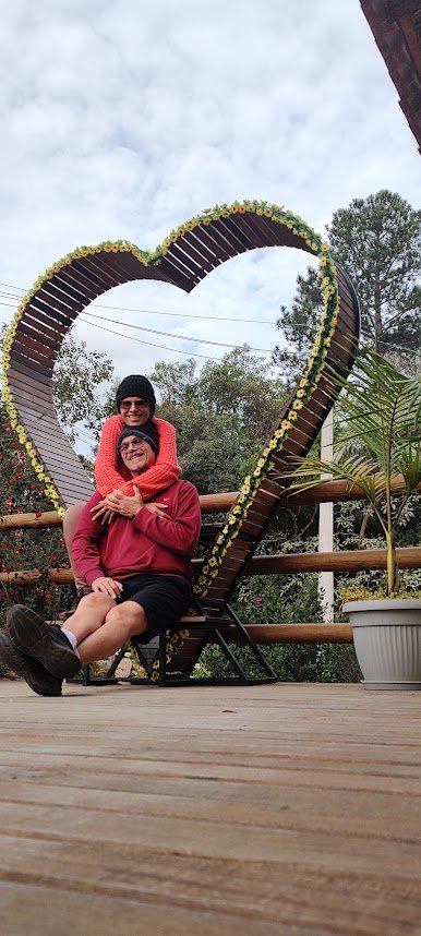 Casal registra um momento especial em um coração decorado com flores em Cunha