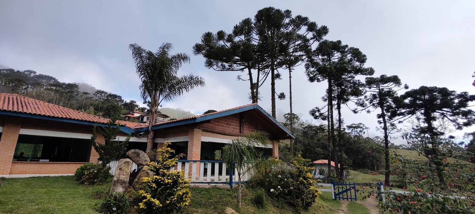 Fachada do Restaurante Rio Manso entre araucárias e jardins